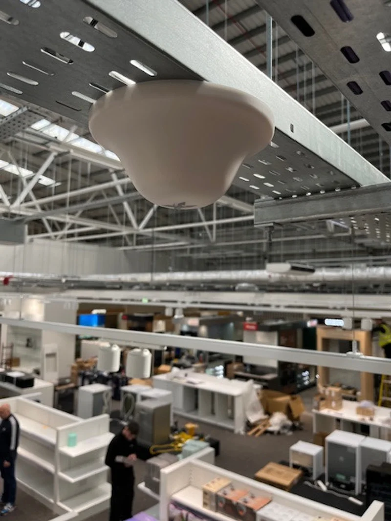 a photograph of a large room with a lot of furniture and a ceiling light