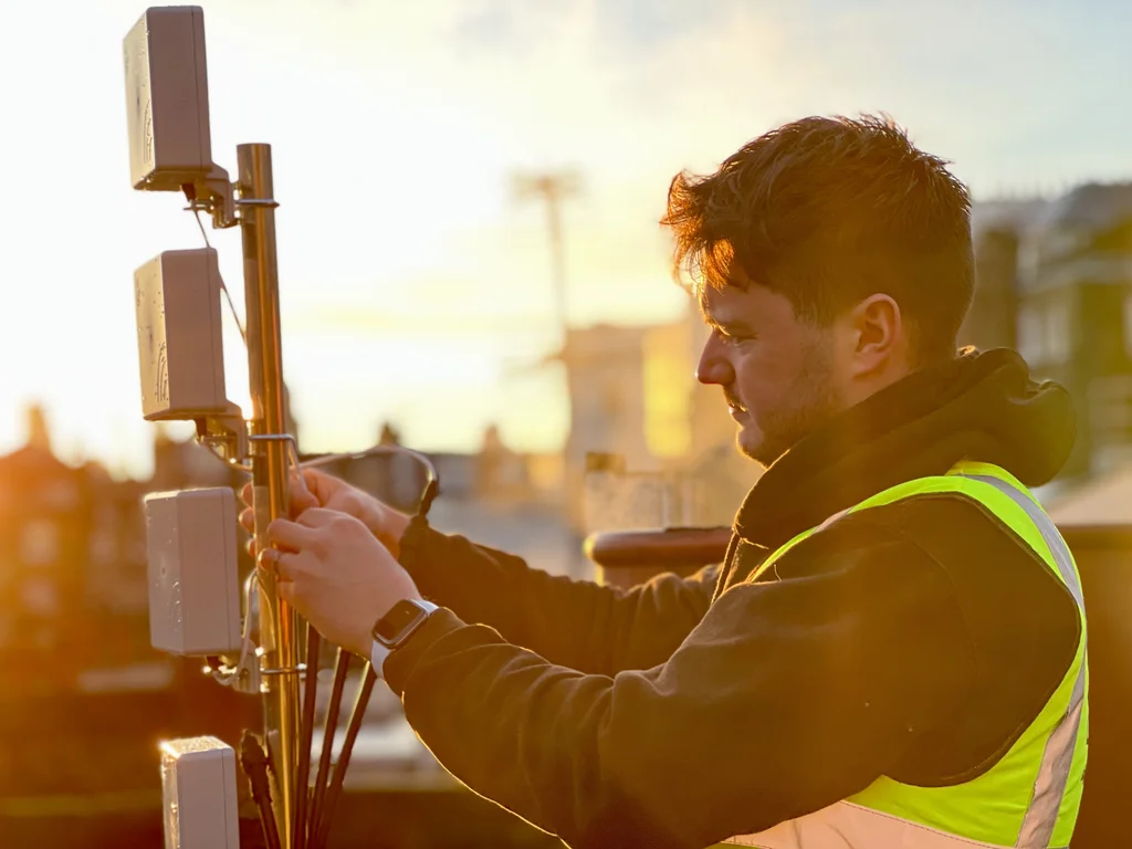 a photograph of a man in a yellow vest is holding a radio