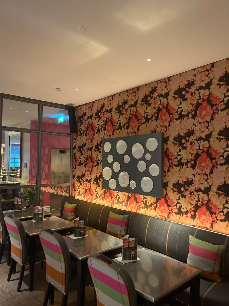 a photograph of a restaurant with a large floral wallpapered wall